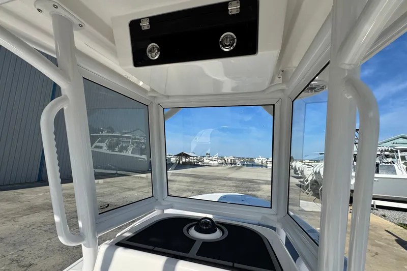 Slide: The Image of Interior view of 2026 Caymas 24 HB boat, showcasing helm and marina background. - 18