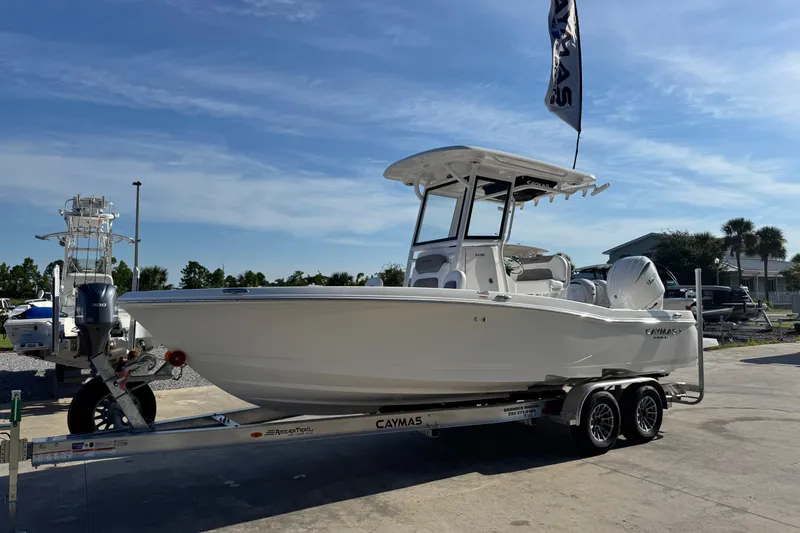 Slide: The Image of 2026 Caymas 24 HB boat on trailer under clear blue sky. - 2