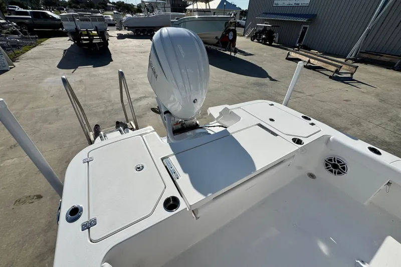 Slide: The Image of 2026 Caymas 24 HB boat with outboard motor, docked in a marina. - 20