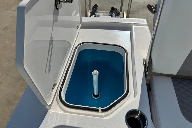 Slide: The Image of Open storage compartment on 2026 Caymas 24 HB boat, featuring a blue interior. - 22
