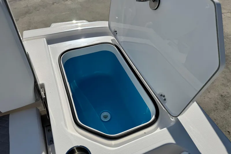 Slide: The Image of Open storage compartment on 2026 Caymas 24 HB boat, featuring a blue interior. - 23