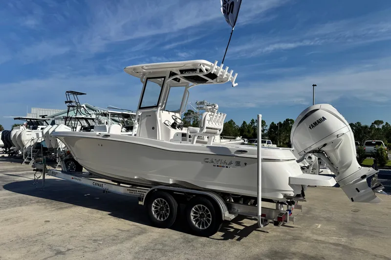 Slide: The Image of 2026 Caymas 24 HB boat with Yamaha engine on trailer, displayed outdoors. - 3