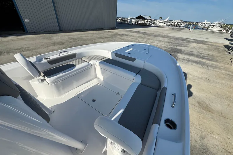 Slide: The Image of 2026 Caymas 24 HB boat interior with seating and storage, dockside view. - 9
