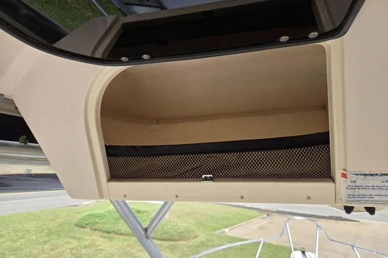 Slide: The Image of Storage compartment on a 2007 Grady-White Seafarer 228 boat, featuring a mesh cover. - 22