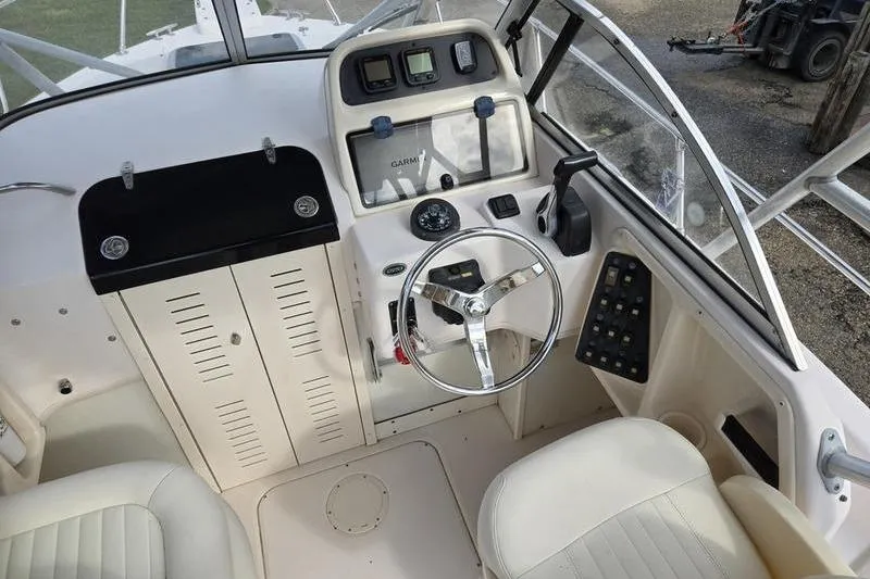 Slide: The Image of 2007 Grady-White Seafarer 228 boat cockpit with steering wheel and control panel. - 8