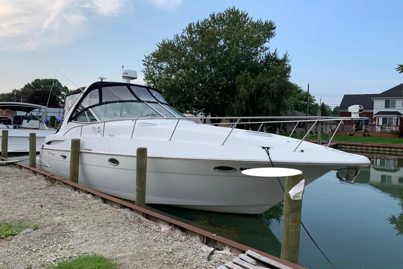 The Image of 2001 Cruisers Yachts 3470 Express docked by a serene waterfront. - 0