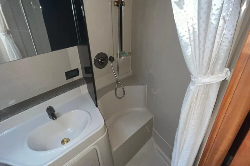 Slide: The Image of 2001 Cruisers Yachts 3470 Express bathroom with sink, shower, and curtain. - 12