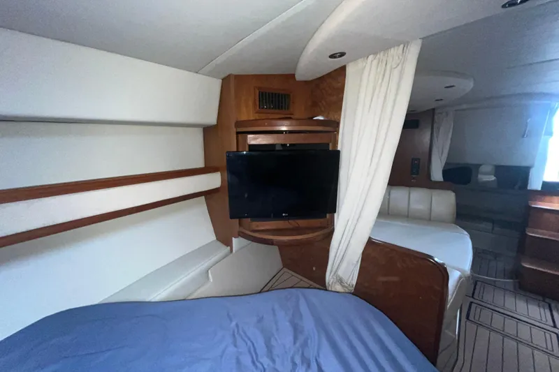 Slide: The Image of 2001 Cruisers Yachts 3470 Express interior with TV, bed, and seating area. - 14