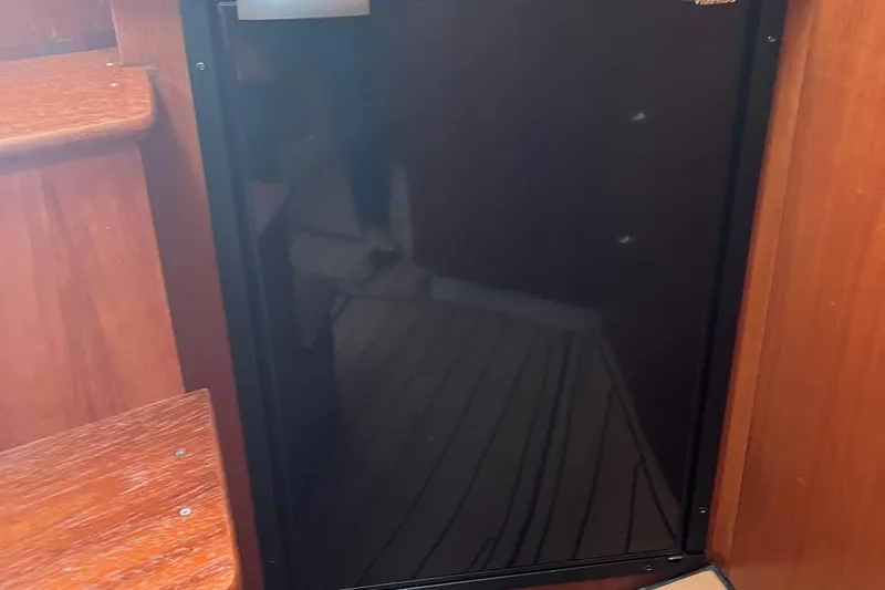 Slide: The Image of 2001 Cruisers Yachts 3470 Express interior with a compact black refrigerator. - 17