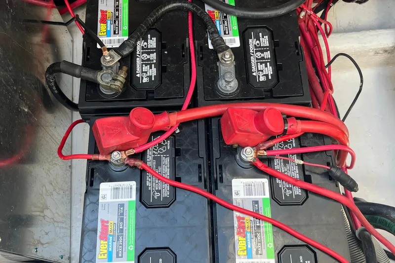 Slide: The Image of Battery setup in a 2001 Cruisers Yachts 3470 Express with red and black cables. - 21