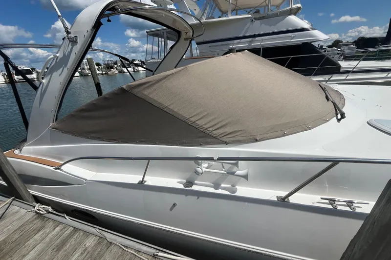 Slide: The Image of 2001 Cruisers Yachts 3470 Express docked, covered, with clear skies and marina background. - 3