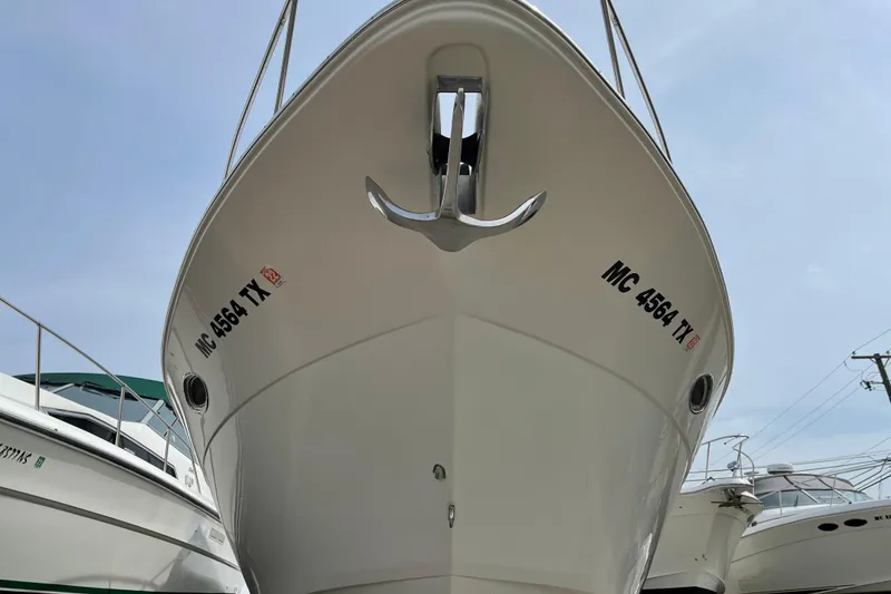 Slide: The Image of 2001 Cruisers Yachts 3470 Express boat, front view, docked with visible registration number. - 4