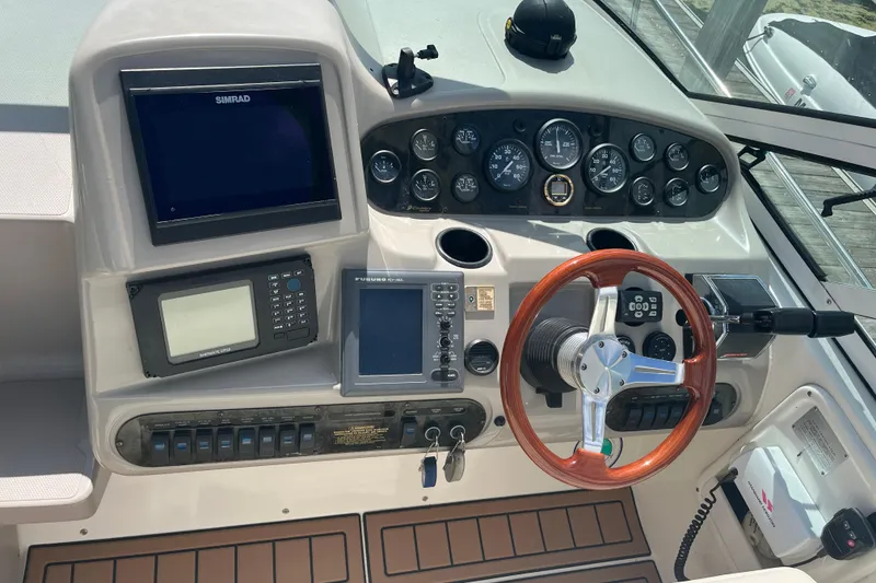 Slide: The Image of 2001 Cruisers Yachts 3470 Express dashboard with navigation instruments and wooden steering wheel. - 7