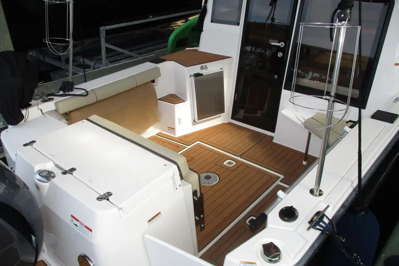 Slide: The Image of 2022 Ranger Tugs R-27 boat interior with teak flooring and seating area. - 16