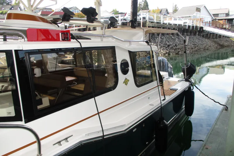 Slide: The Image of 2022 Ranger Tugs R-27 boat docked in a marina, side view. - 28