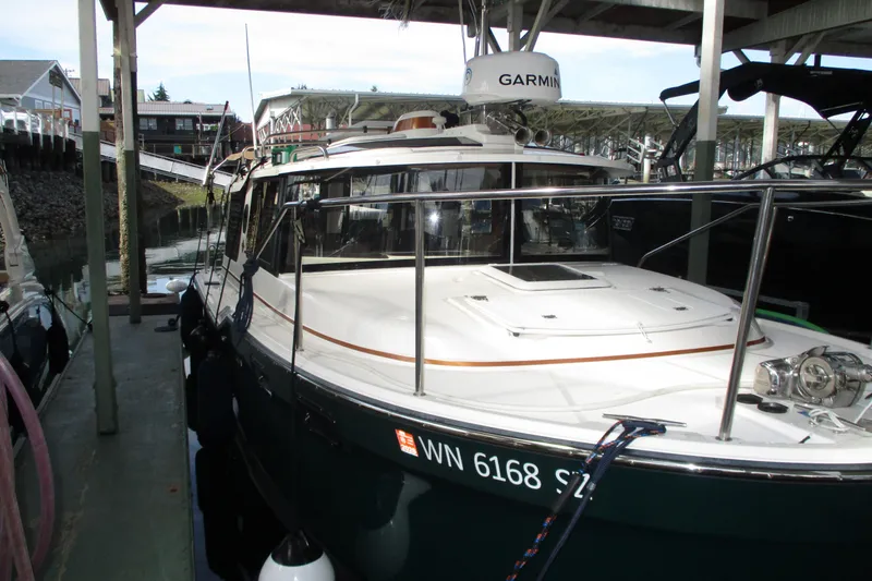 Slide: The Image of 2022 Ranger Tugs R-27 boat docked, featuring Garmin equipment and sleek design. - 29