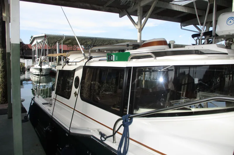 Slide: The Image of 2022 Ranger Tugs R-27 docked under a covered marina. - 30