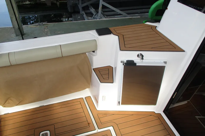 Slide: The Image of 2022 Ranger Tugs R-27 interior with teak-style flooring and cushioned seating. - 35