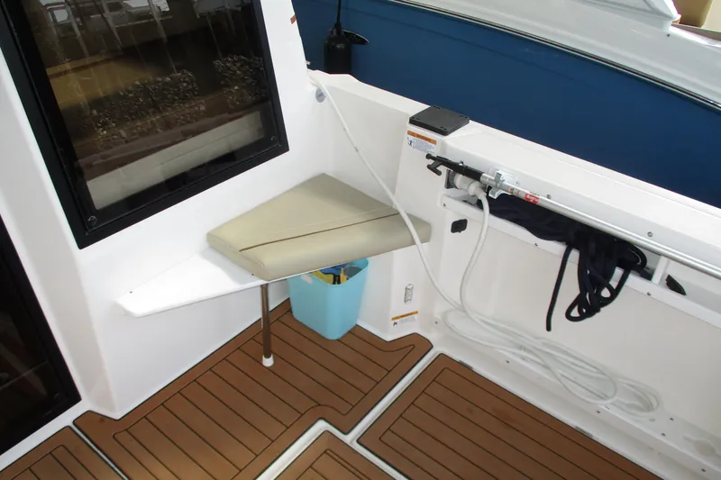 Slide: The Image of 2022 Ranger Tugs R-27 boat interior with cushioned seat and wooden flooring. - 36