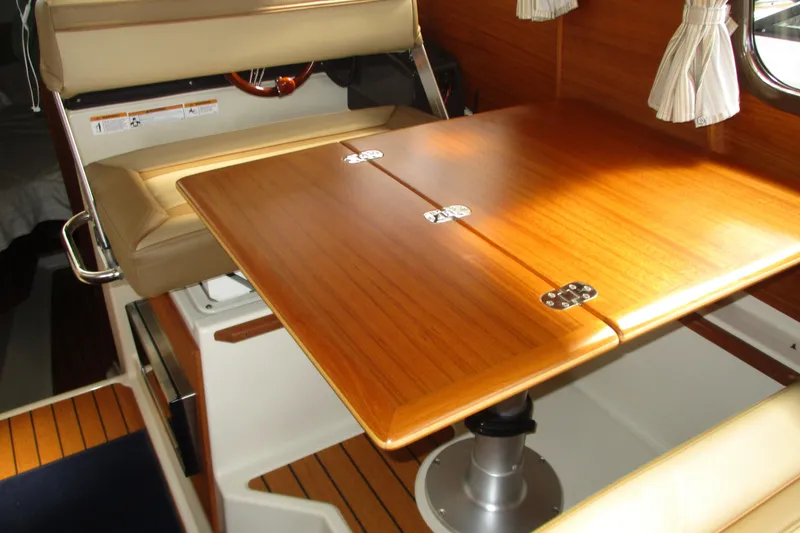 Slide: The Image of Interior of 2022 Ranger Tugs R-27 featuring a wooden table and beige seating. - 49