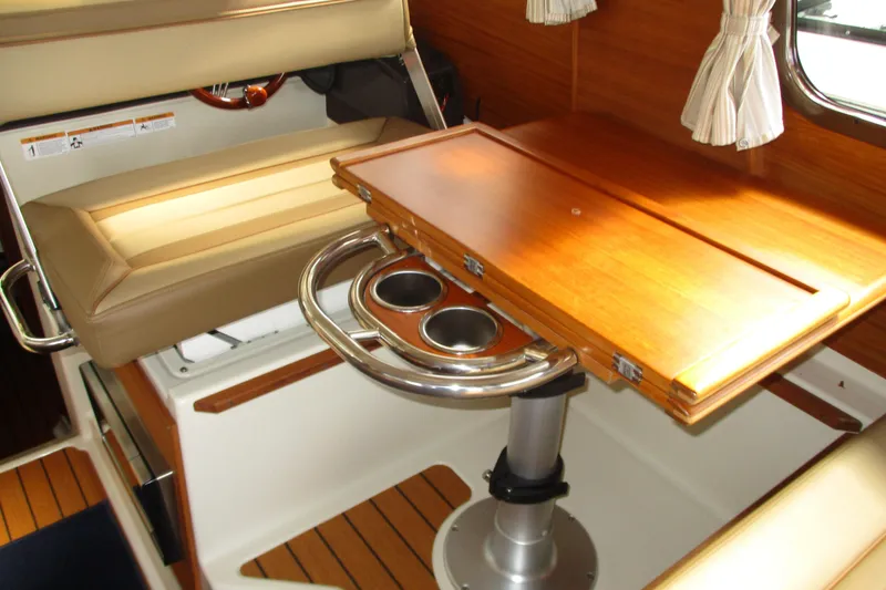 Slide: The Image of 2022 Ranger Tugs R-27 interior with wooden table and cushioned seating. - 51