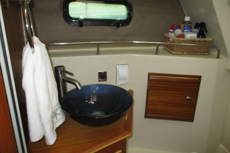 Slide: The Image of 2022 Ranger Tugs R-27 bathroom with modern sink, towel, and storage cabinet. - 55