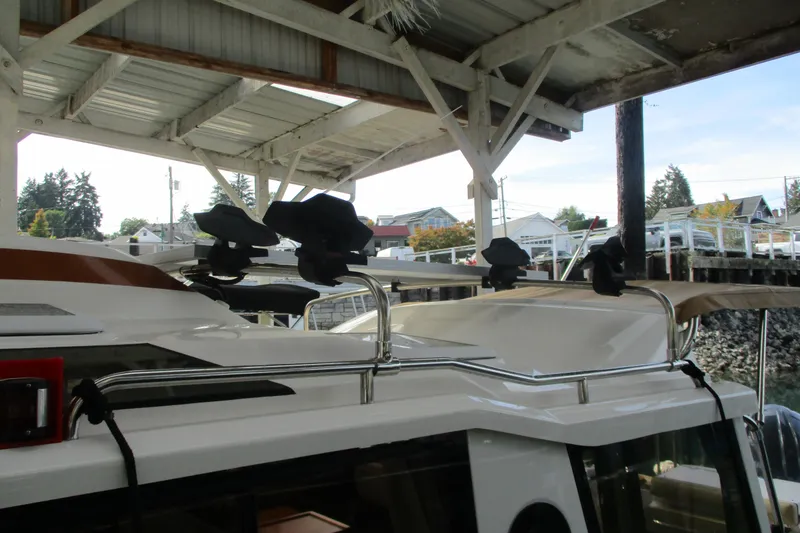 Slide: The Image of 2022 Ranger Tugs R-27 boat under a dock, showcasing roof details and surroundings. - 68