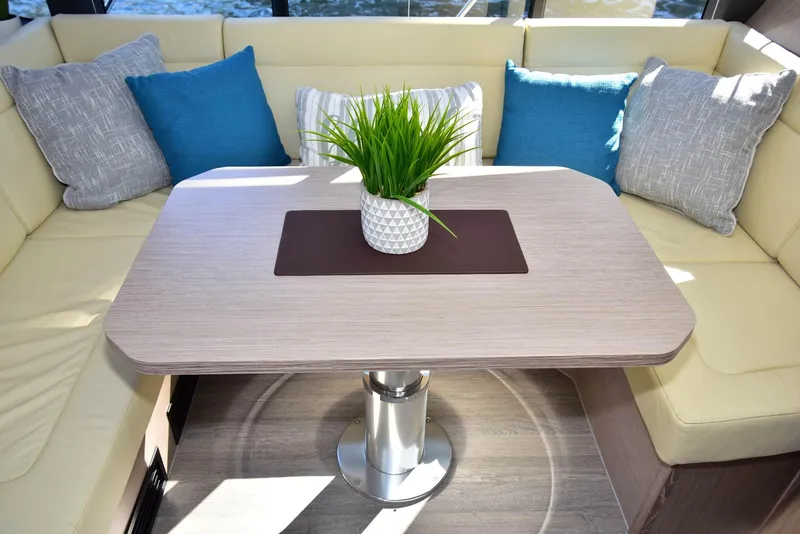 Slide: The Image of 2022 Sealine C430 yacht interior with modern table, cushioned seating, and decorative plant. - 27