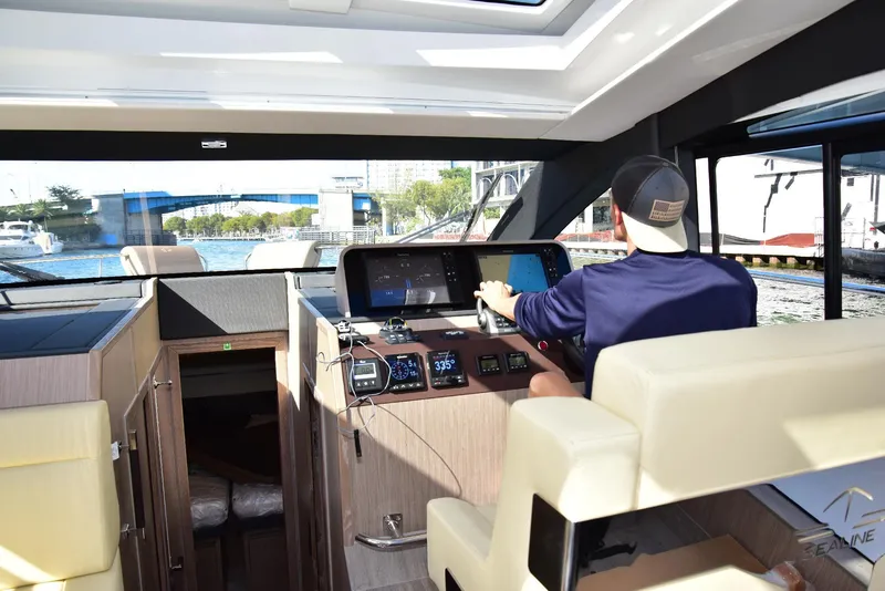Slide: The Image of Interior view of a 2022 Sealine C430 yacht with a person navigating. - 31