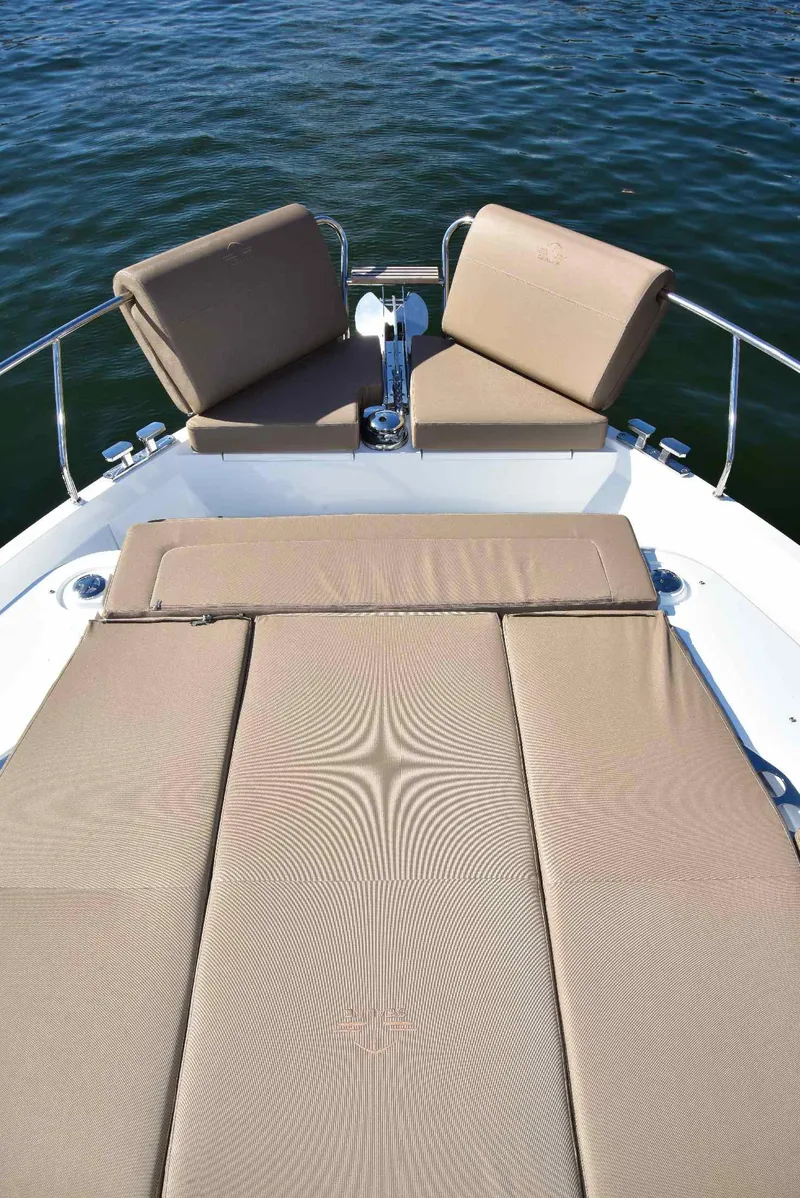 Slide: The Image of Sealine C430 2022 yacht with beige sunbathing cushions on deck, overlooking calm water. - 34