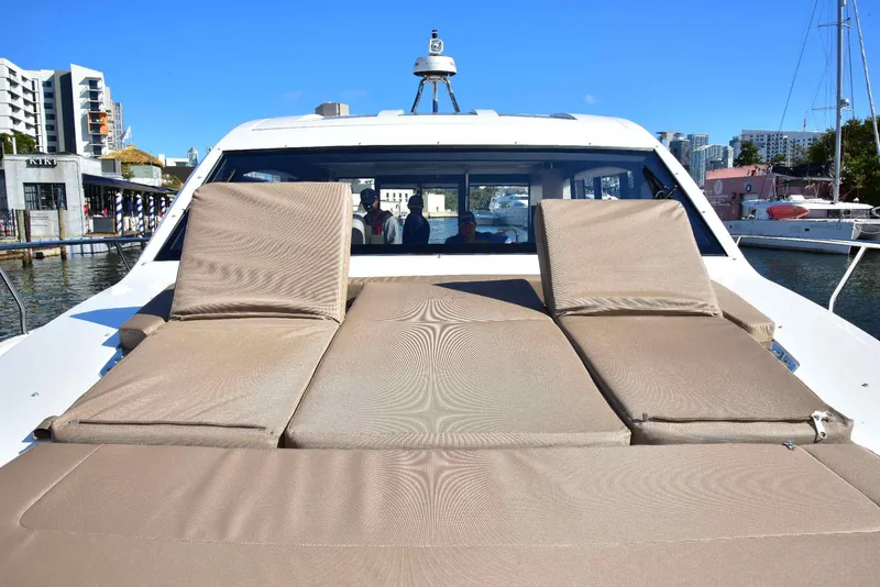 Slide: The Image of 2022 Sealine C430 yacht with sunbathing cushions, docked in a marina under clear blue skies. - 36