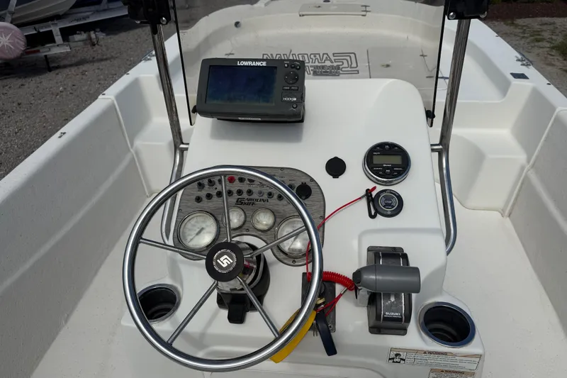 Slide: The Image of 2016 Carolina Skiff 218 DLV boat console with steering wheel and navigation equipment. - 17