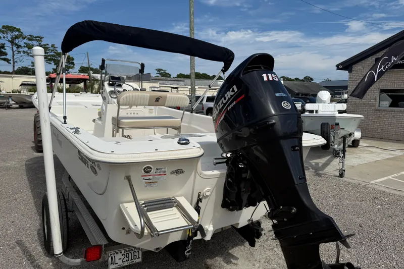 Slide: The Image of 2016 Carolina Skiff 218 DLV boat with Suzuki 115 outboard motor, parked outdoors. - 4