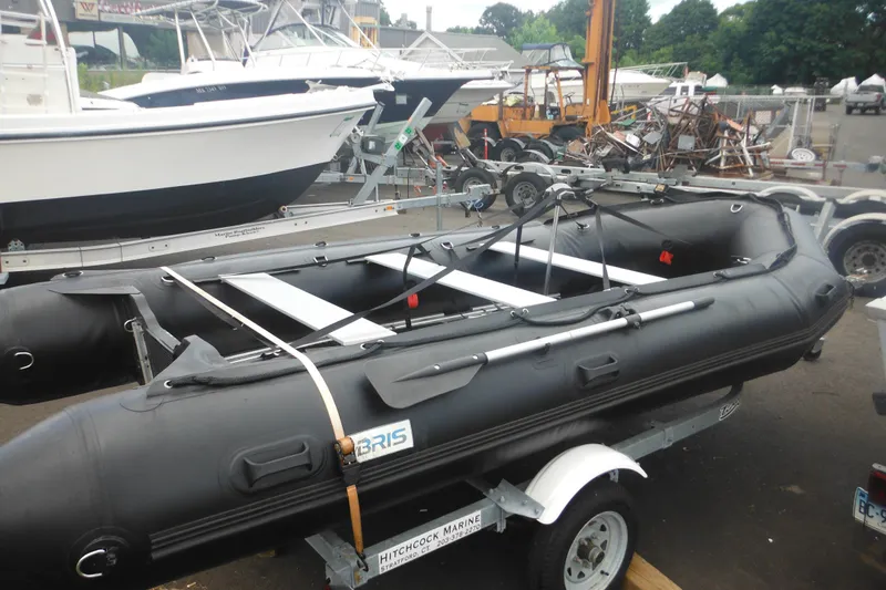 Slide: The Image of 2020 Bris BSA470 inflatable boat on trailer at marina, surrounded by other boats. - 3