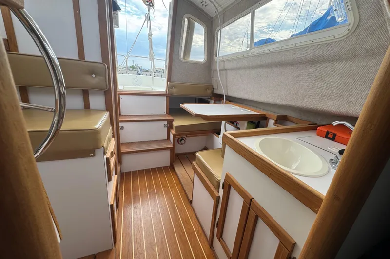 Slide: The Image of Interior of 2022 Com-Pac CP 23 Pilothouse with wooden flooring and compact seating. - 11