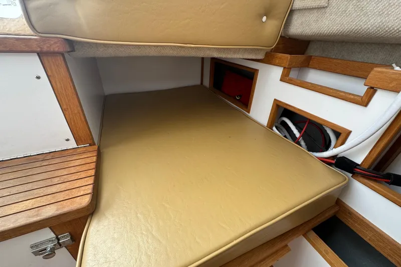 Slide: The Image of 2022 Com-Pac CP 23 Pilothouse interior with cushioned seating and wooden accents. - 13