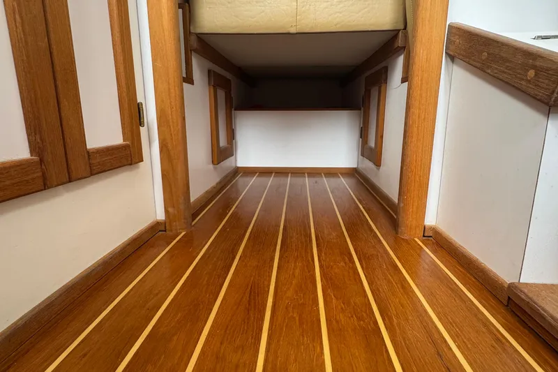 Slide: The Image of 2022 Com-Pac CP 23 Pilothouse interior with polished wooden flooring and cozy cabin space. - 16