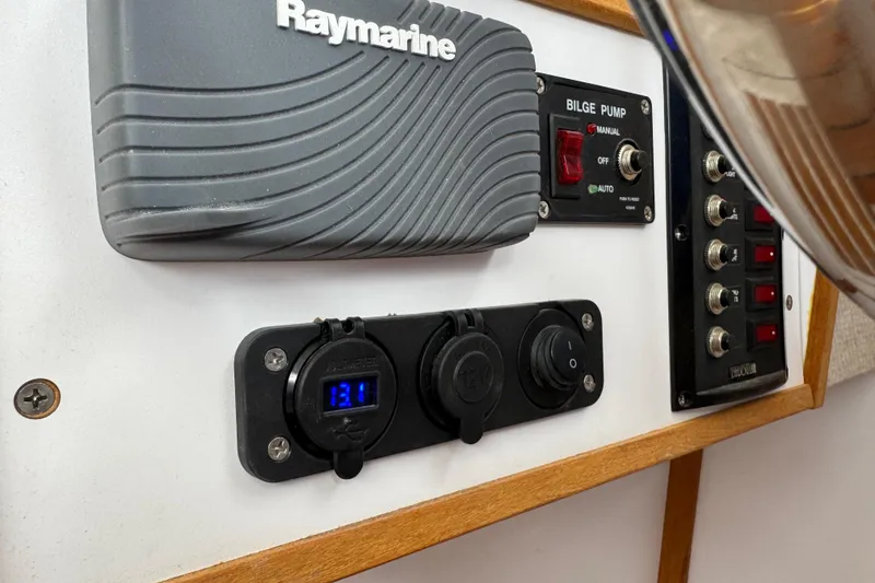 Slide: The Image of Control panel of 2022 Com-Pac CP 23 Pilothouse with Raymarine equipment and bilge pump switches. - 22