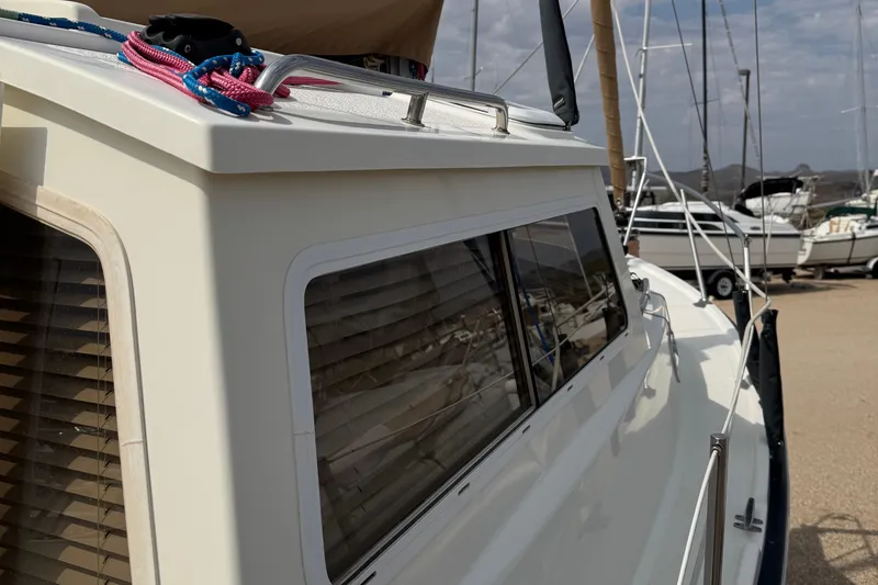 Slide: The Image of 2022 Com-Pac CP 23 Pilothouse sailboat with sleek windows and vibrant ropes on deck. - 25