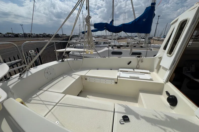 Slide: The Image of 2022 Com-Pac CP 23 Pilothouse sailboat cockpit with seating, docked at marina. - 26