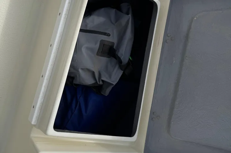 Slide: The Image of Storage compartment on 2022 Com-Pac CP 23 Pilothouse with a gray bag inside. - 33