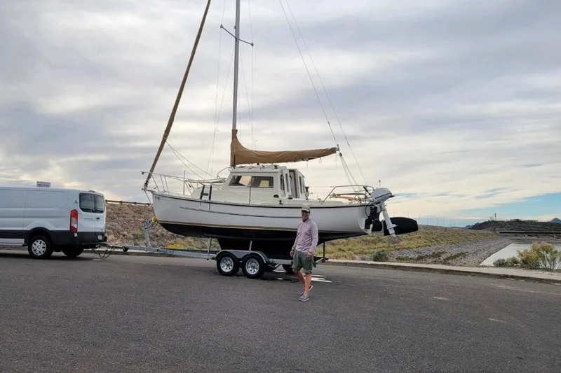 Slide: The Image of 2022 Com-Pac CP 23 Pilothouse sailboat on trailer, parked near a van. - 35