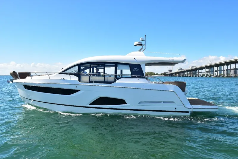 Slide: The Image of 2022 Sealine C430 yacht cruising on open water under clear blue skies. - 11