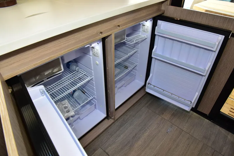 Slide: The Image of Dual refrigerators in 2022 Sealine C430 yacht kitchen, open with empty shelves. - 24