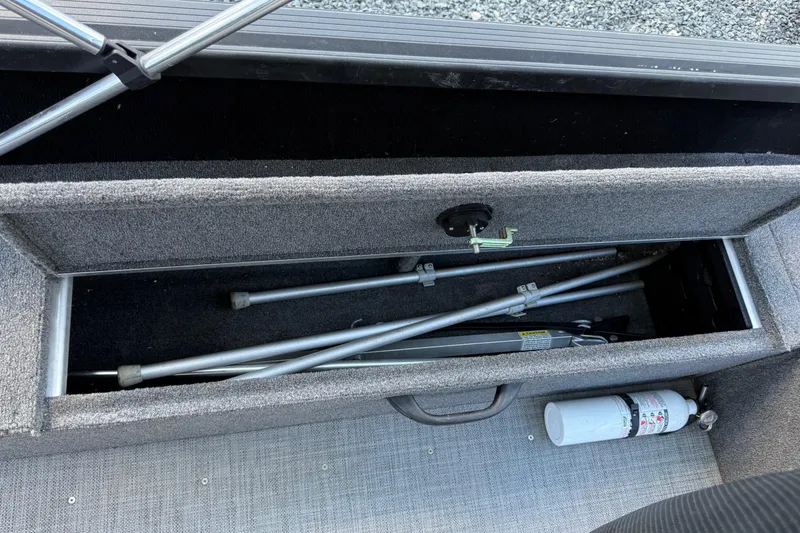 Slide: The Image of Storage compartment in 2019 Alumacraft Competitor 185 CS boat with metal rods and fire extinguisher. - 11