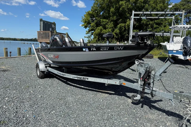Slide: The Image of 2019 Alumacraft Competitor 185 CS boat on trailer by a lakeside. - 4
