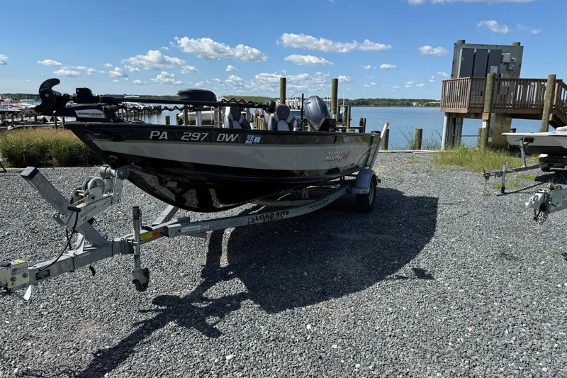 Slide: The Image of 2019 Alumacraft Competitor 185 CS boat on trailer by a lakeside dock. - 5