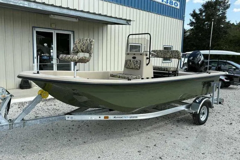Slide: The Image of 2026 Carolina Skiff E18 JVX TH boat on trailer, parked outside a building. - 2