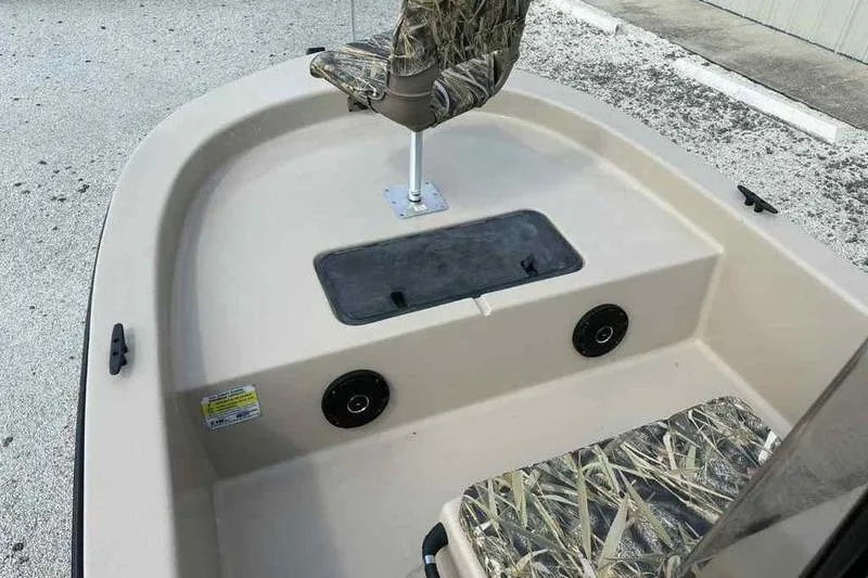 Slide: The Image of 2026 Carolina Skiff E18 JVX TH boat interior with camo seats and storage compartment. - 8