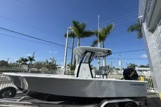 Slide: The Image of 2026 Sportsman Masters 227 Bay Boat with outboard motor, parked outdoors. - 2